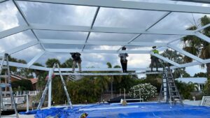 Three people building a steel frame structure