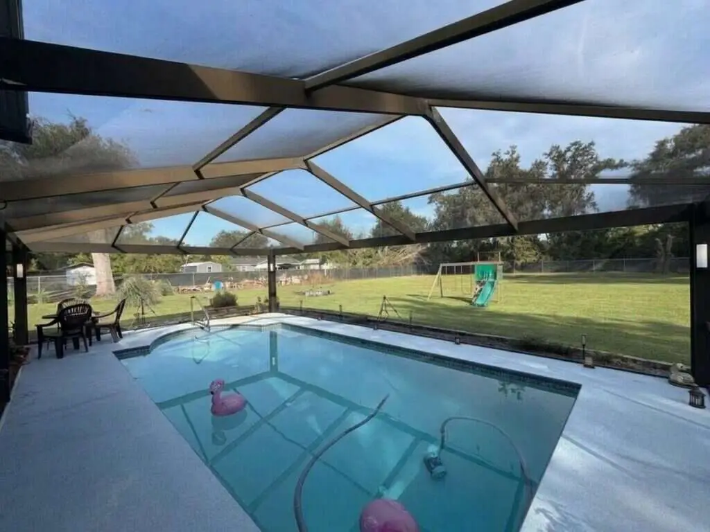 Black aluminum pool cage freshly painted and rescreened with a new panoramic picture-window screen (clear view)