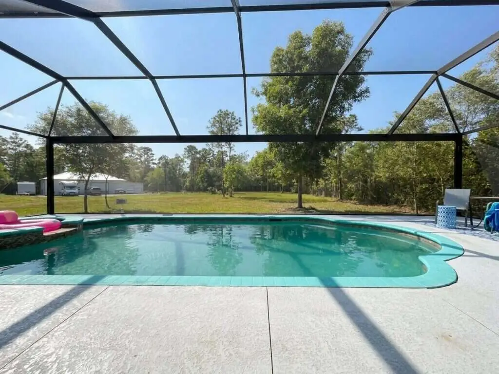 Black aluminum pool cage freshly painted and rescreened with a new panoramic picture-window screen (clear view)
