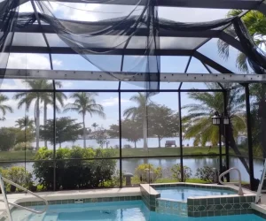 Ladders by pool under screened roof